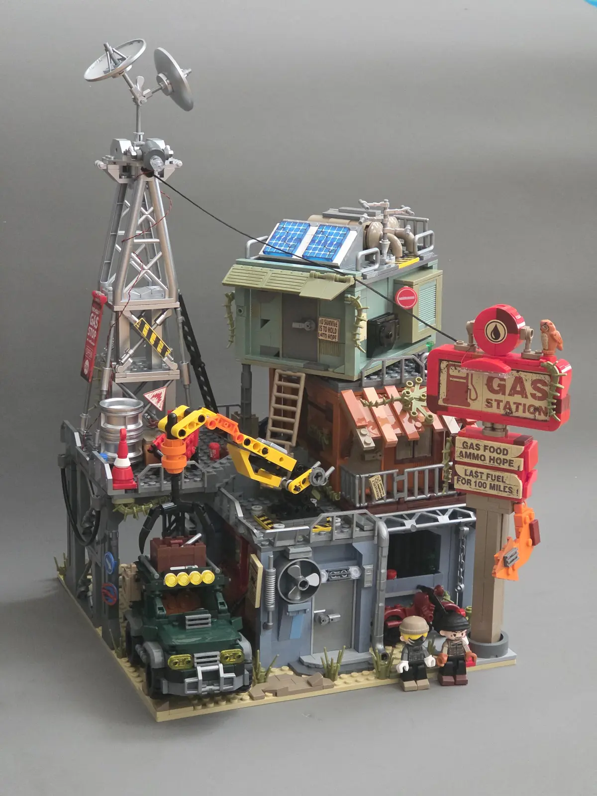 Completed IAMBRICK Doomsday Gas Station model with tower, roadside sign, crane, off-road vehicle and two figures