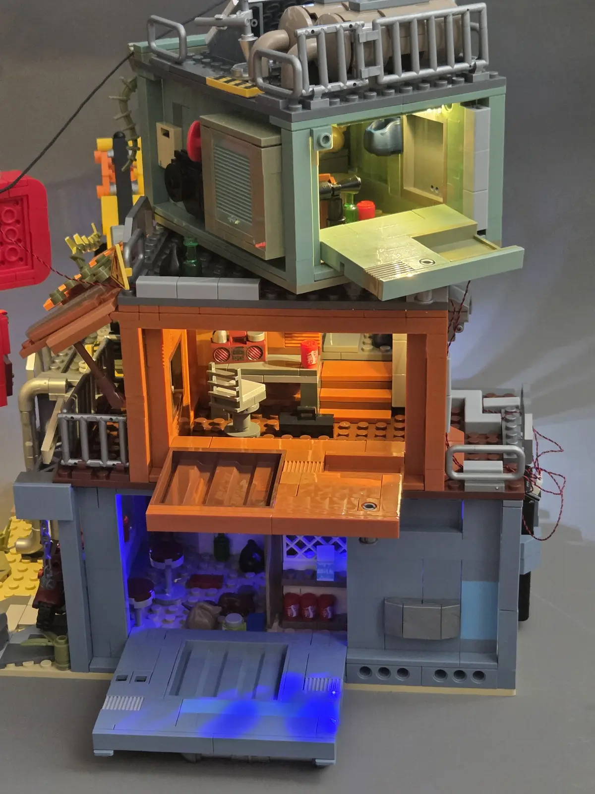 Rear view of the IAMBRICK Doomsday Gas Station with all three hinged access panels open and interior lighting visible