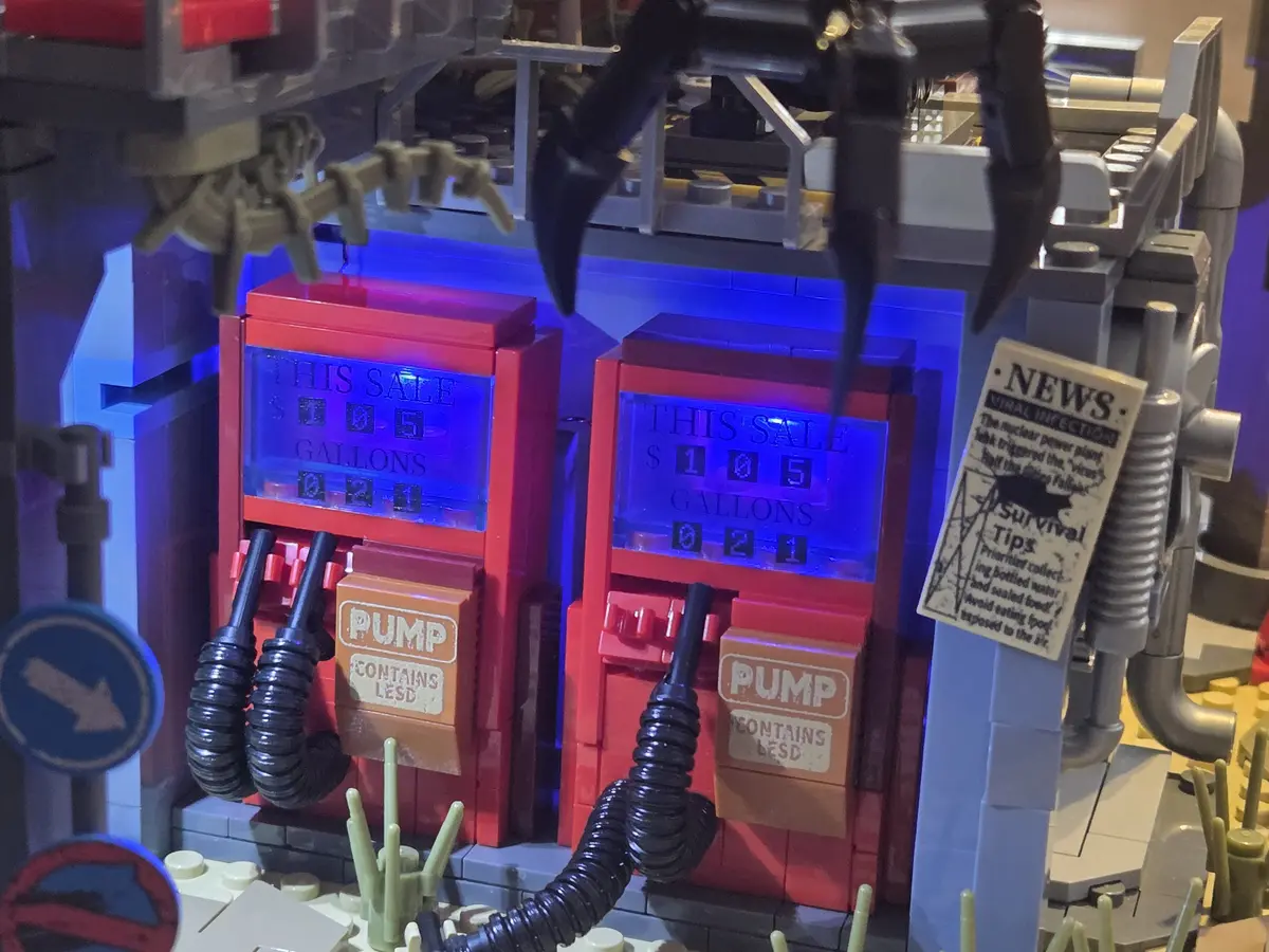 Two red fuel pumps with printed displays and weathered pump panels