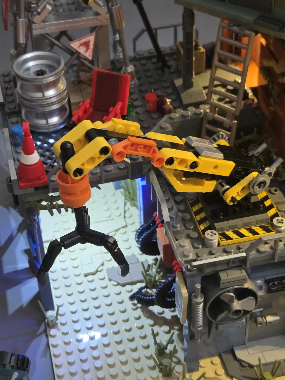 Yellow repair crane and black claw above the gas station forecourt