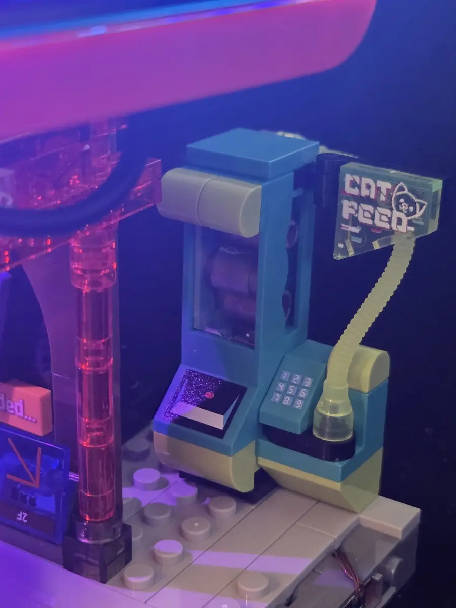 Illuminated cat-food vending machine beside the Manga Shop