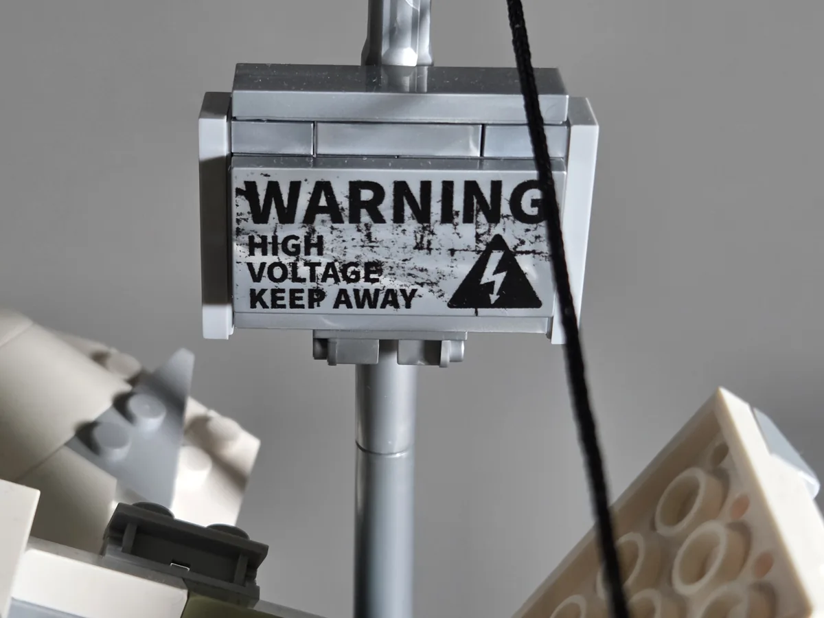 Printed high-voltage warning sign on the electricity pylon