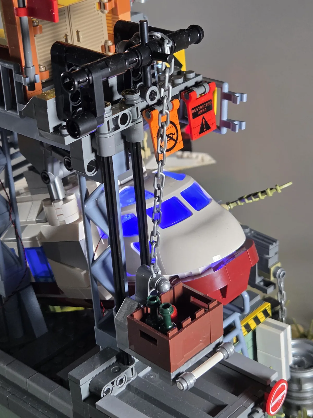 Supply crate lowered beside the blue-lit aircraft nose